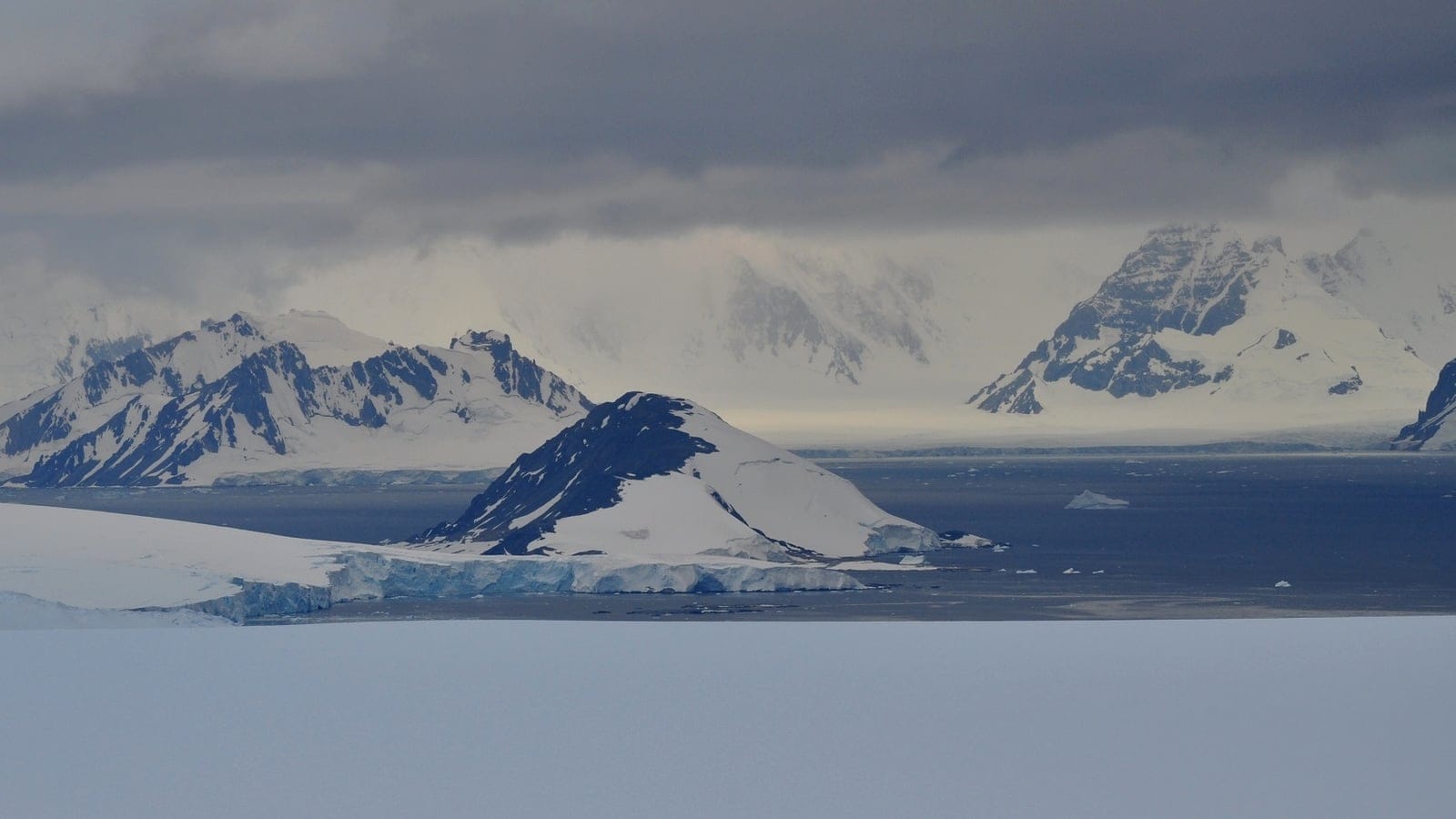 Panoramic view of Laubeuf Fjord on the Antarctic Peninsula seen from the Wormald Ice Piedmont on Adelaide Island, with ice cliffs, snow-covered mountains, and offshore islands.