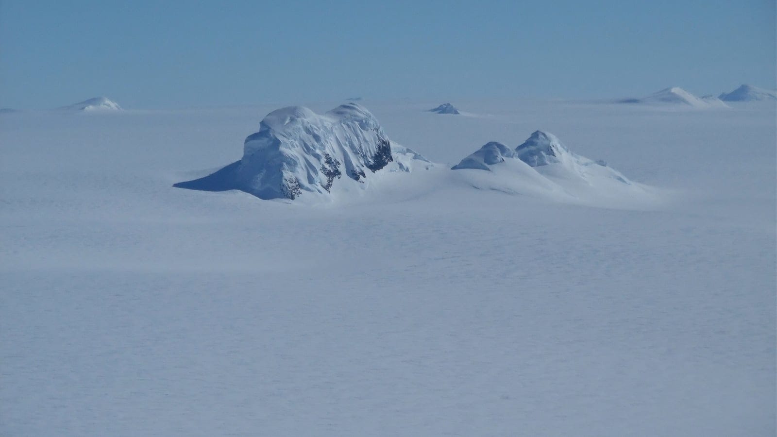 Snow-plastered nunataks breaking through the ice sheet on Thurston Island, West Antarctica.