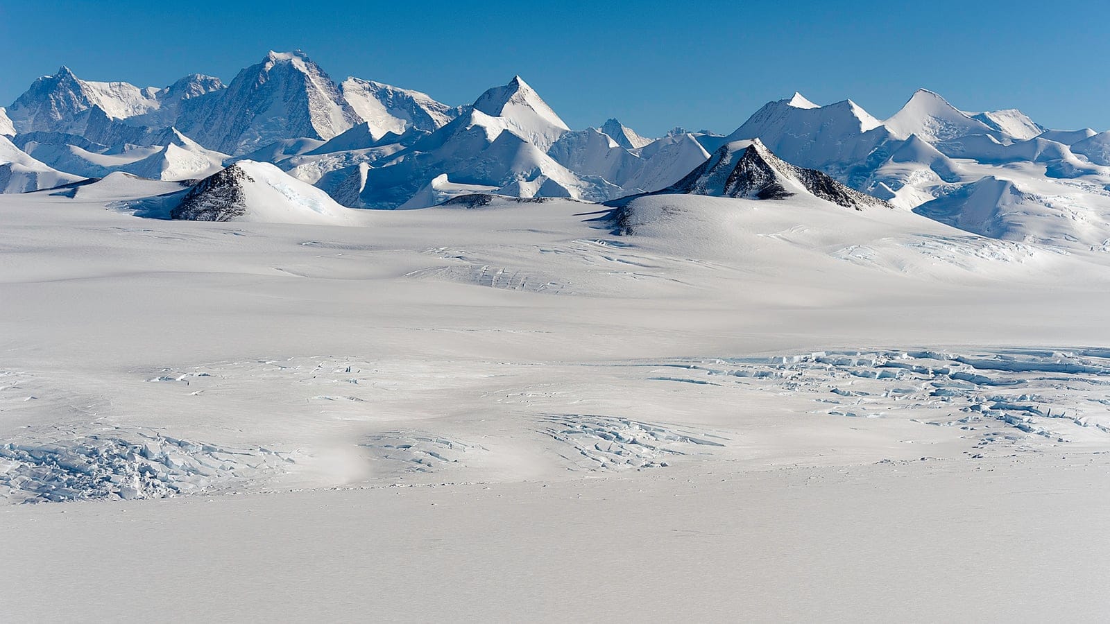 Crevassed snowfield below the serrated peaks of the Sentinel Range, Ellsworth Mountains, Antarctica.