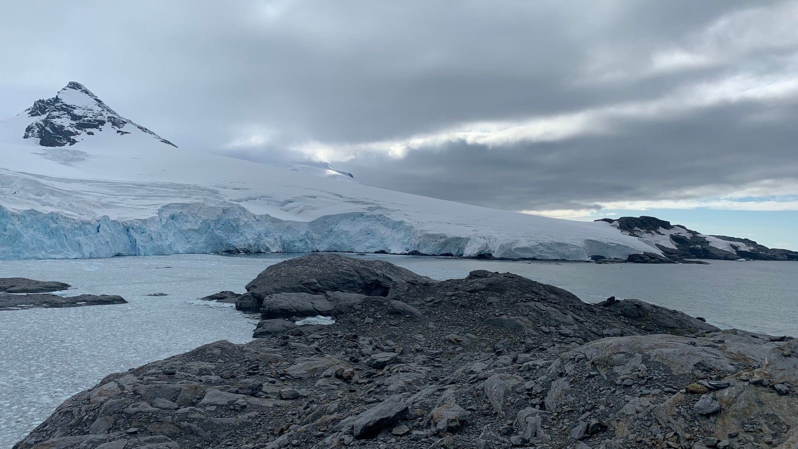 Glacier front and bare rock shore above brash ice on Coronation Island, South Orkney Islands.