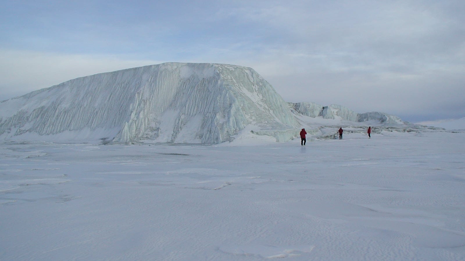 Grounded iceberg fluted with meltwater channels on flat sea ice, New Harbour, Victoria Land.