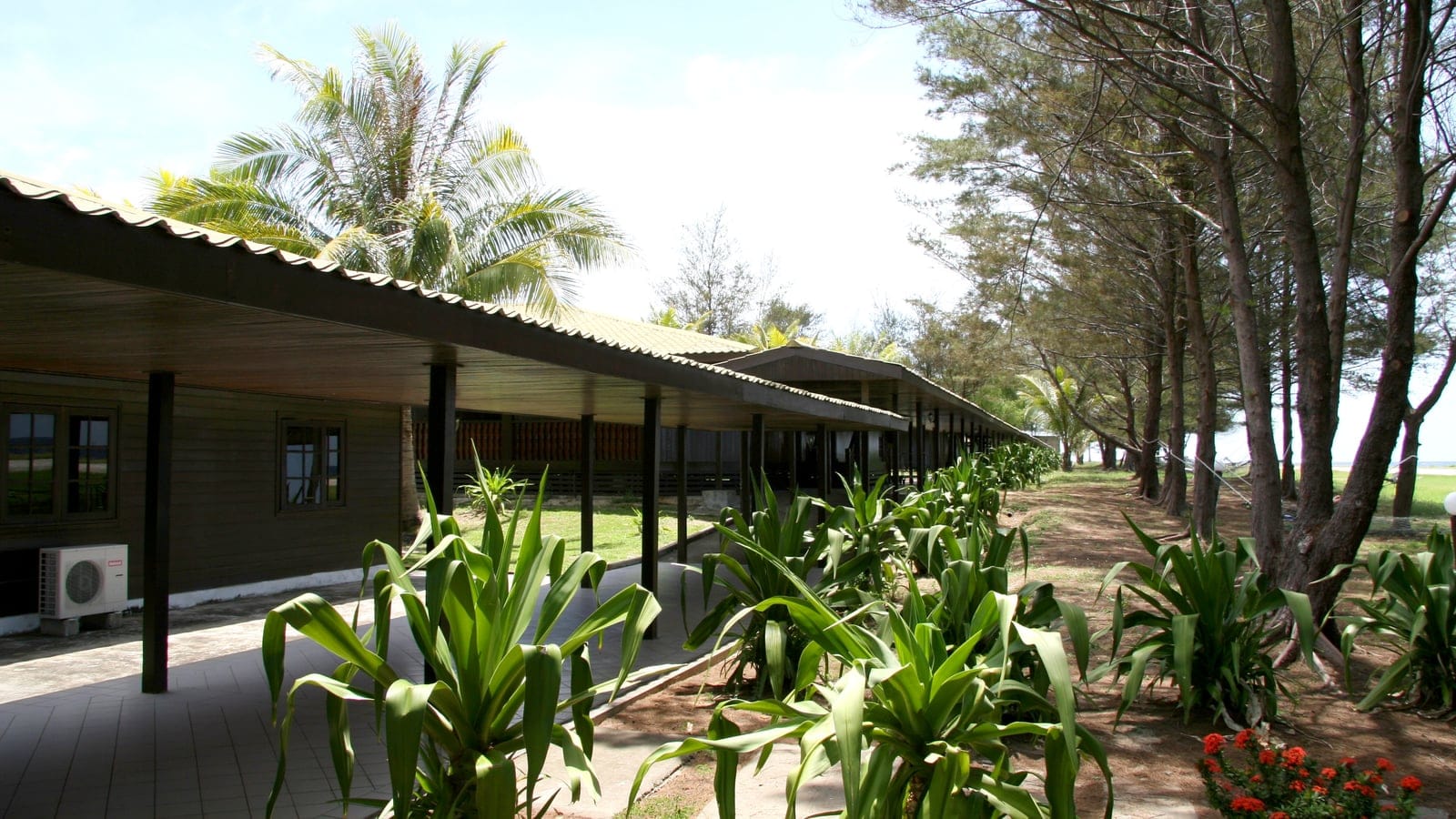Casuarina trees and a long stilted building on the resort island at Swallow Reef, Spratly Islands.