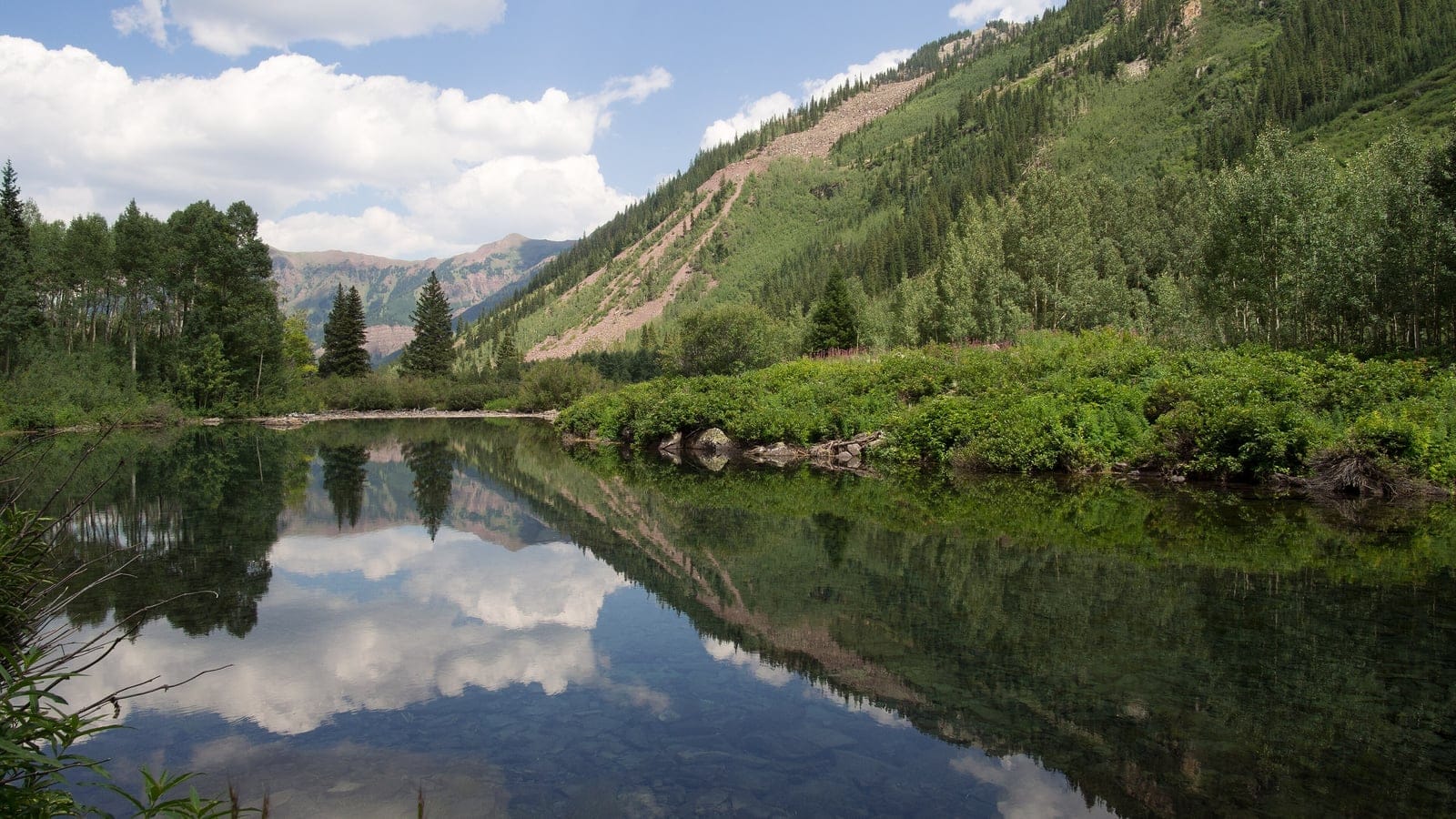 Colorado Rockies conifer forest, alpine lake, and mountain slopes at Maroon Bells.