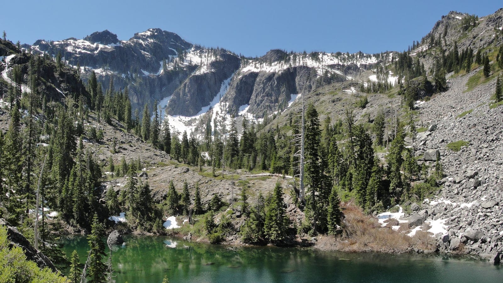 Conifers around a glacial tarn below granite cirques in the Siskiyou Wilderness, California.