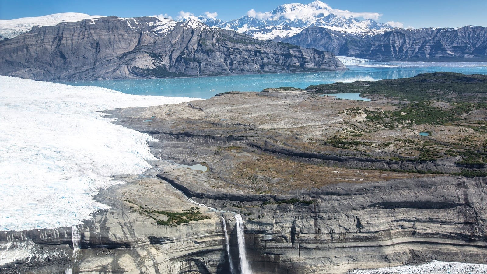 Glacier, meltponds and sparse tundra above Icy Bay below the Saint Elias range, Alaska.