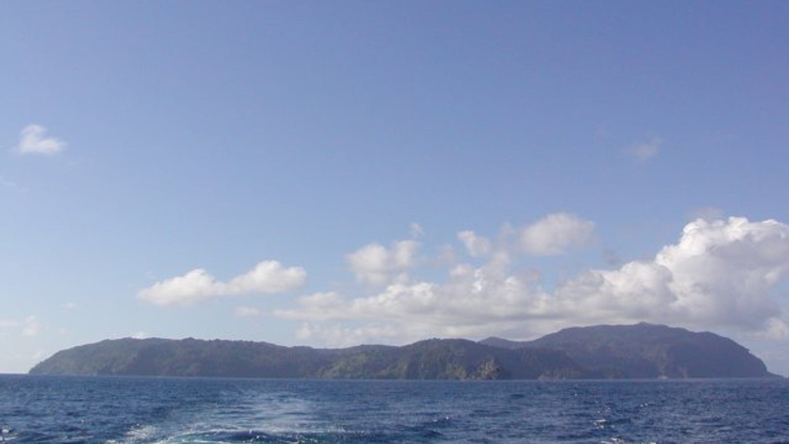 Cocos Island as a low forested silhouette across open Pacific swell, Costa Rica.