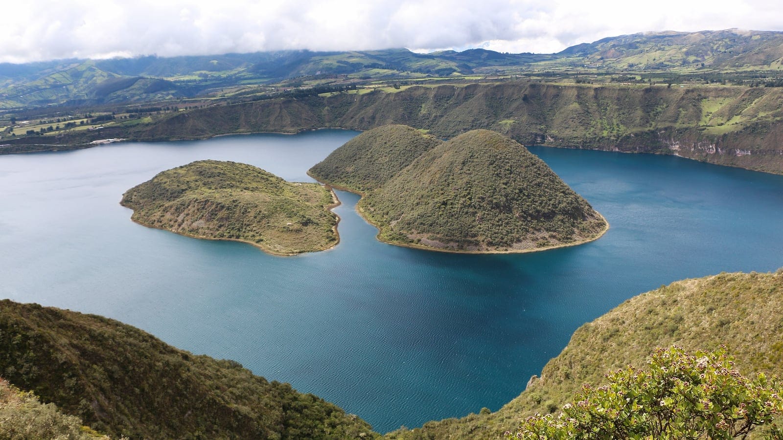 Domos de lava cubiertos de matorral en la laguna del cráter de Cuicocha, bajo el borde andino, Ecuador.