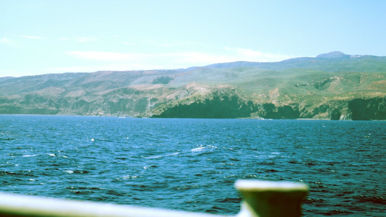 Grass and scrub covered volcanic ridges of Socorro Island seen across open water, Revillagigedo, Mexico.