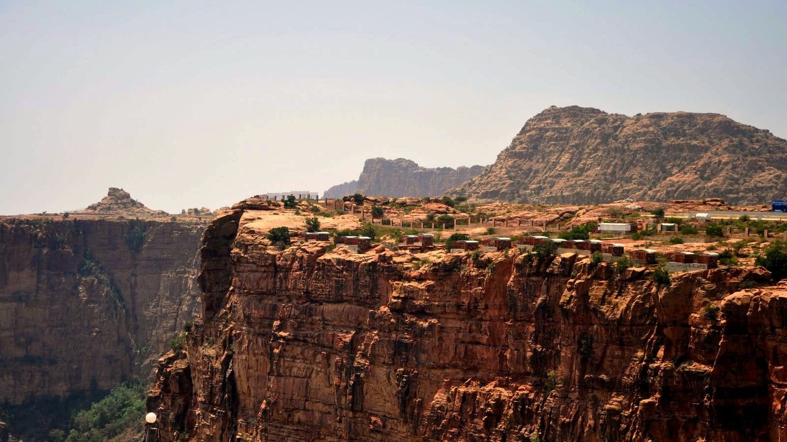 Layered sandstone escarpment with a built-up clifftop rim above Habala Valley, Asir, Saudi Arabia.