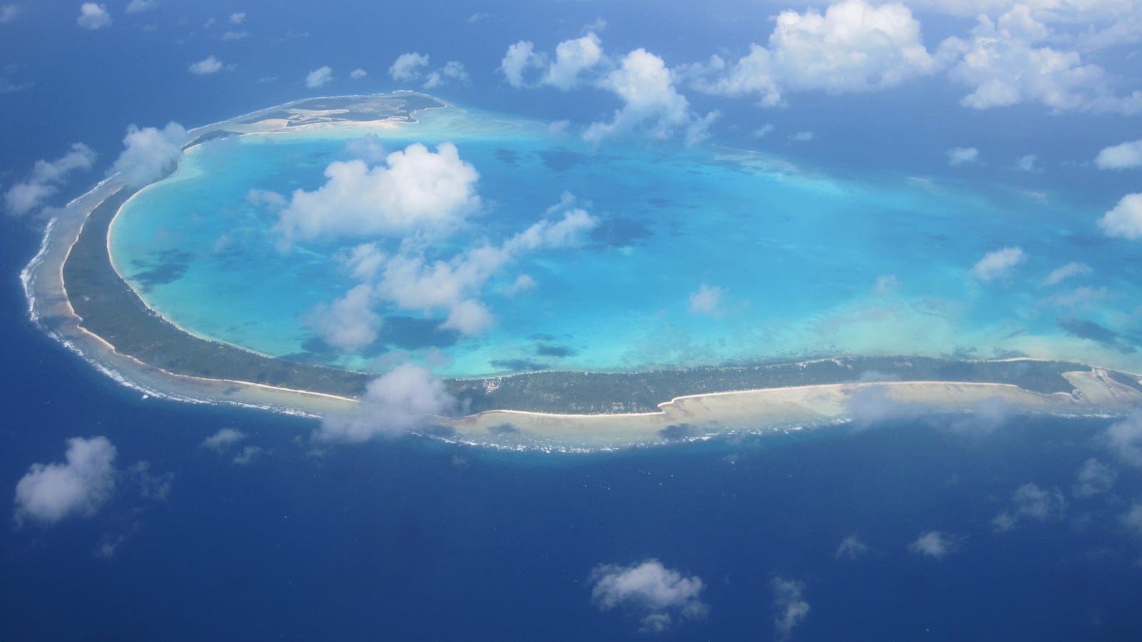 Aerial view of the reef rim, motu and pale lagoon of Onotoa Atoll, Gilbert Islands, Kiribati.