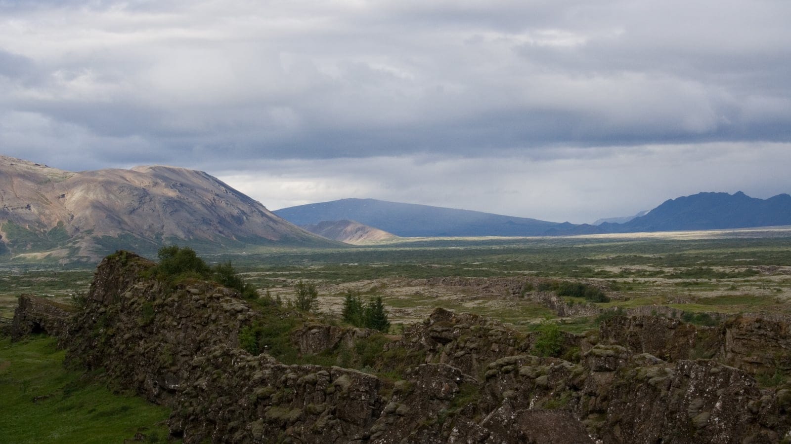 Afloramientos de lava cubiertos de musgo y matorral bajo en la llanura del rift en Thingvellir, Islandia.