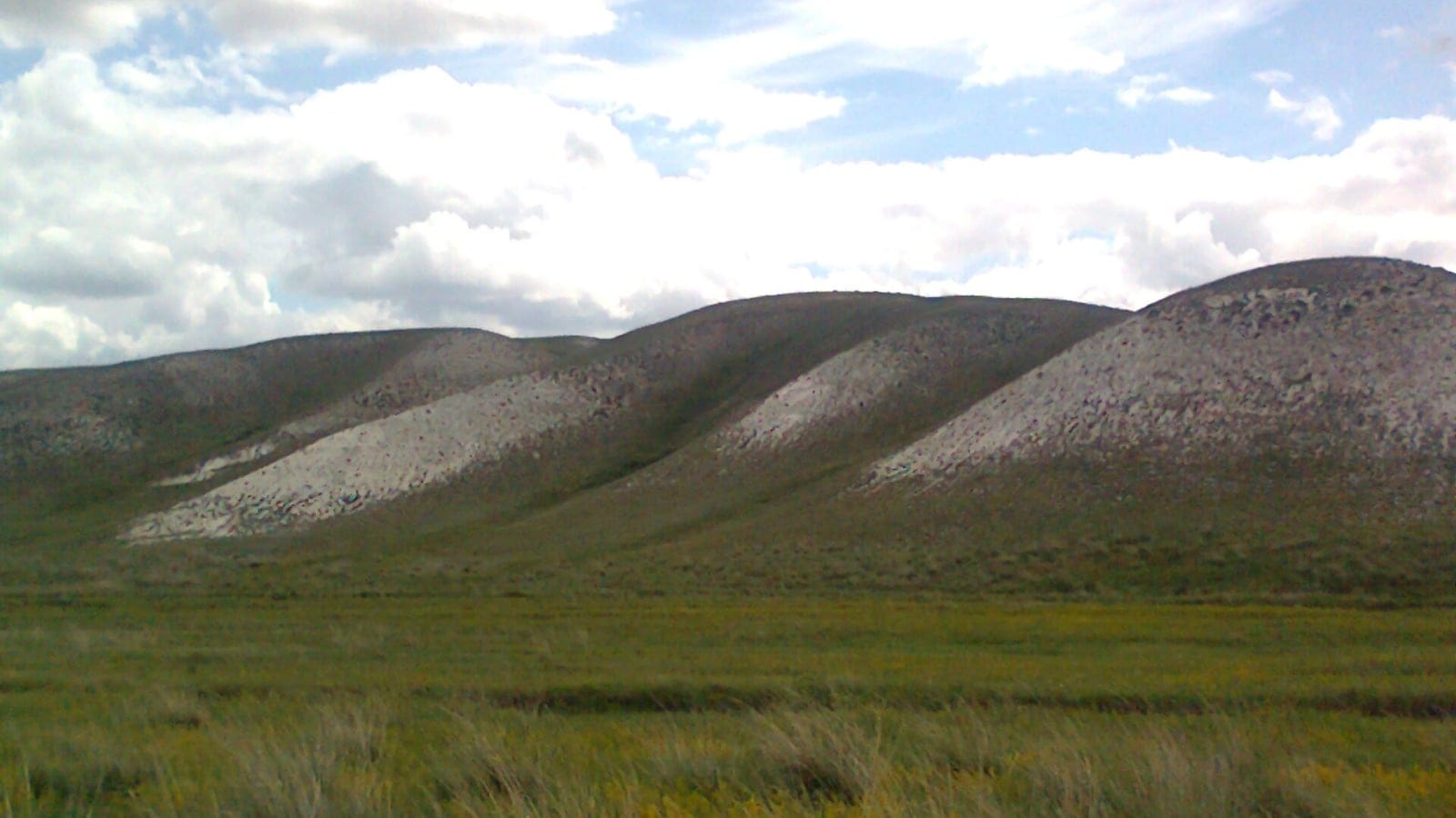 Chalk outcrops on low hills above steppe grassland in West Kazakhstan.