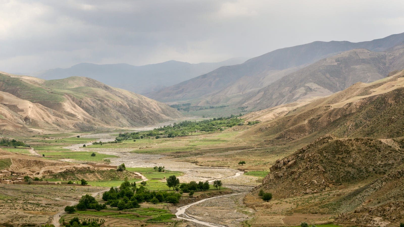 Irrigated fields and poplars along the Kunduz River between bare hills, Afghanistan.