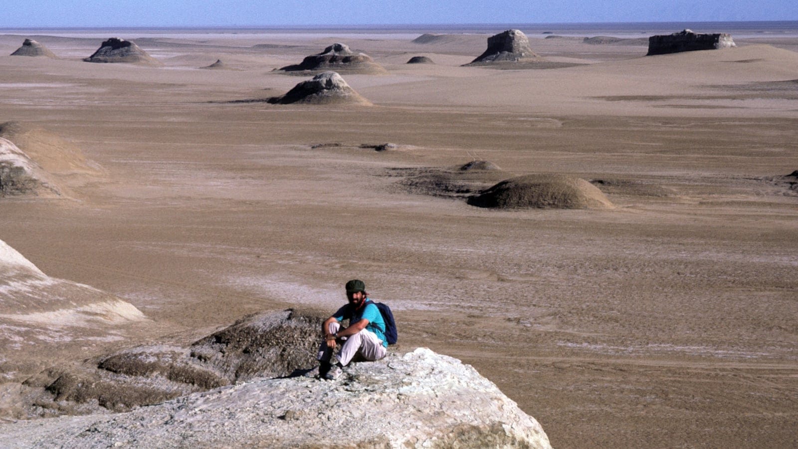 Wind-cut yardang mounds scattered across a bare gravel plain in the Qaidam Basin, China.